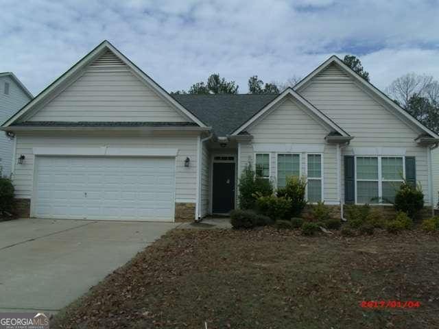 ranch-style home featuring a garage and driveway