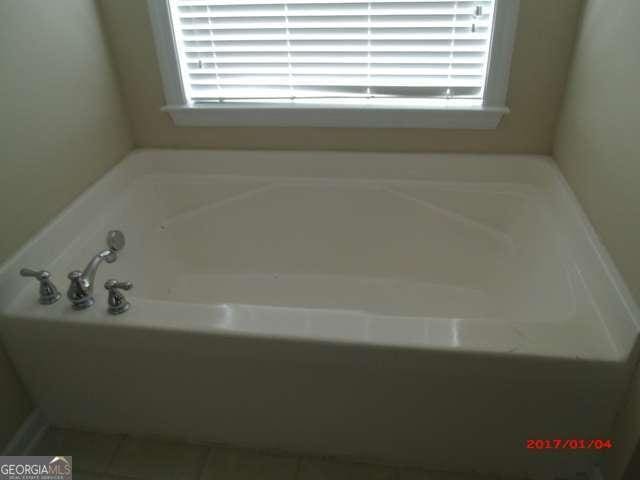 bathroom with a bath and tile patterned floors