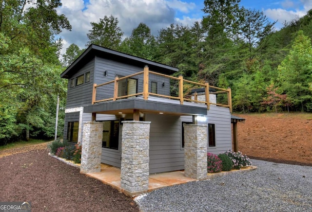 contemporary house with a deck and stone siding