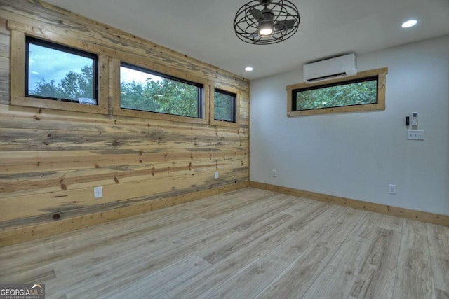 unfurnished room with wood walls, recessed lighting, an AC wall unit, and wood finished floors