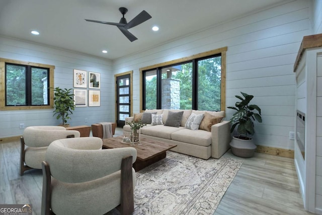 living room with light wood finished floors, a ceiling fan, and recessed lighting