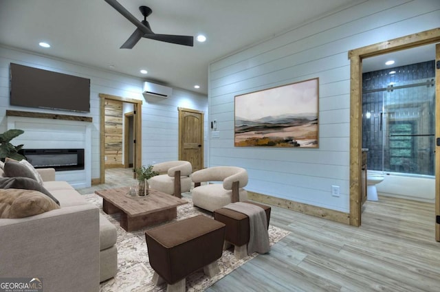 living room with a glass covered fireplace, an AC wall unit, ceiling fan, and recessed lighting