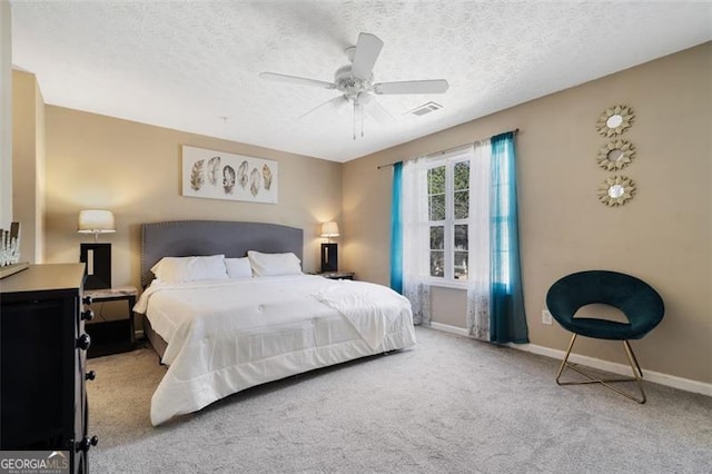 carpeted bedroom featuring a textured ceiling, a ceiling fan, visible vents, and baseboards