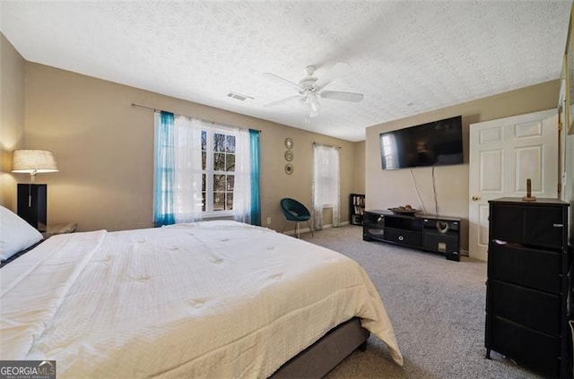 carpeted bedroom with a textured ceiling, visible vents, and a ceiling fan