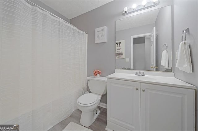 full bath with wood finished floors, curtained shower, vanity, and toilet