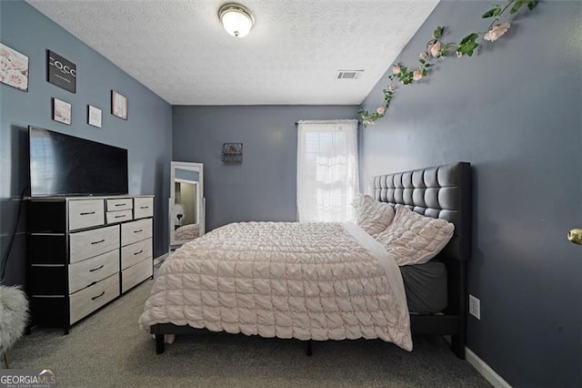 carpeted bedroom with visible vents, a textured ceiling, and baseboards