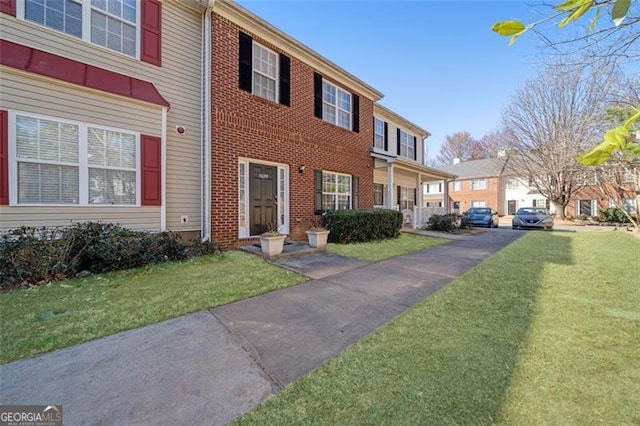 view of front of home with a front yard and brick siding