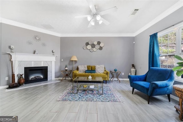 living room featuring ornamental molding, wood finished floors, visible vents, and baseboards