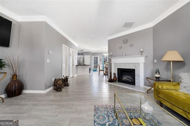 living room with baseboards, visible vents, and ornamental molding