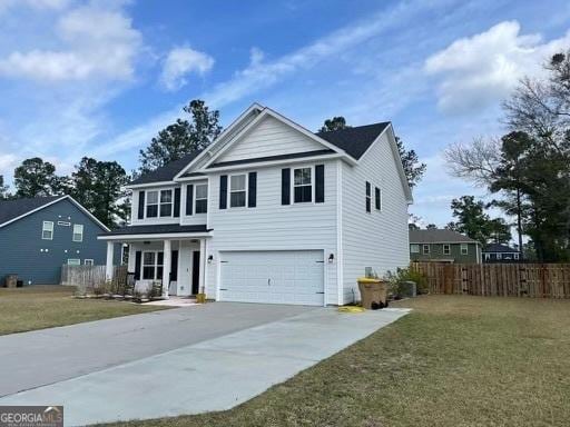 traditional-style home featuring a garage, concrete driveway, a front yard, and fence