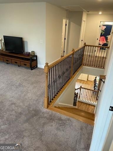 interior space with carpet, an upstairs landing, and baseboards