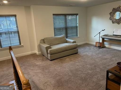 sitting room featuring carpet flooring and baseboards