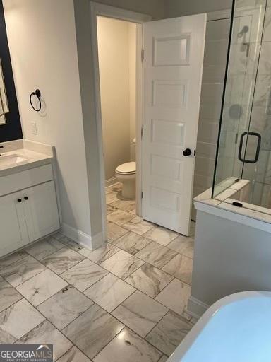 bathroom with baseboards, toilet, marble finish floor, vanity, and a shower stall