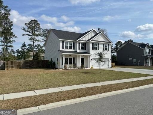 view of front of property featuring concrete driveway, an attached garage, board and batten siding, a front yard, and fence