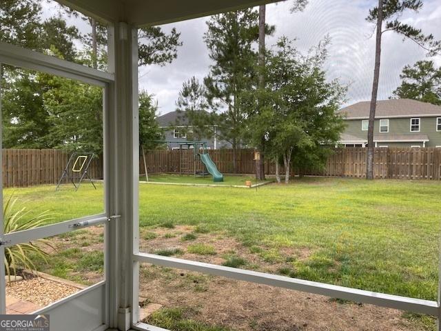 view of yard featuring a playground and a fenced backyard