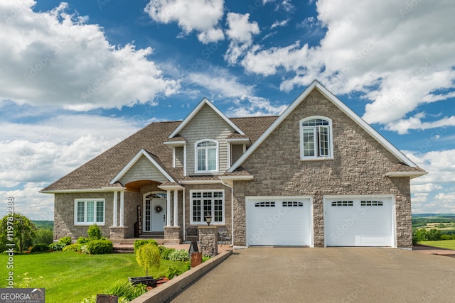 craftsman inspired home featuring a shingled roof, a front lawn, and aphalt driveway