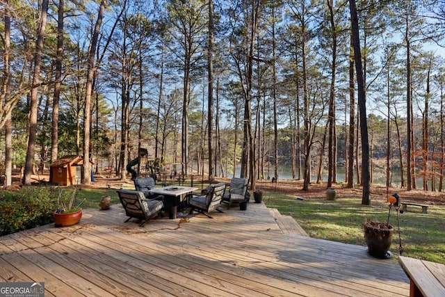 wooden deck with an outdoor fire pit and a playground