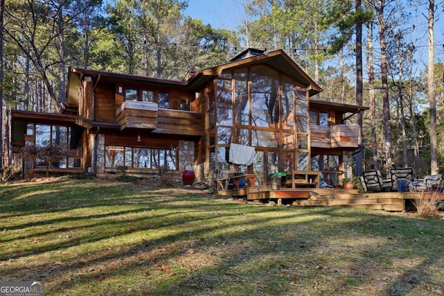 rear view of property with a yard and a wooden deck