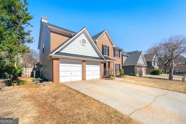 traditional-style home featuring a garage, driveway, brick siding, and a chimney