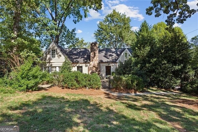 view of front facade with a chimney and a front yard