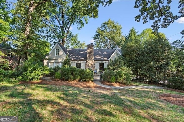 view of front facade with a front yard and a chimney