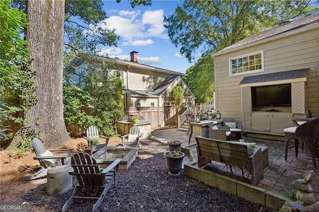 view of yard with a patio, fence, and an outdoor living space with a fire pit