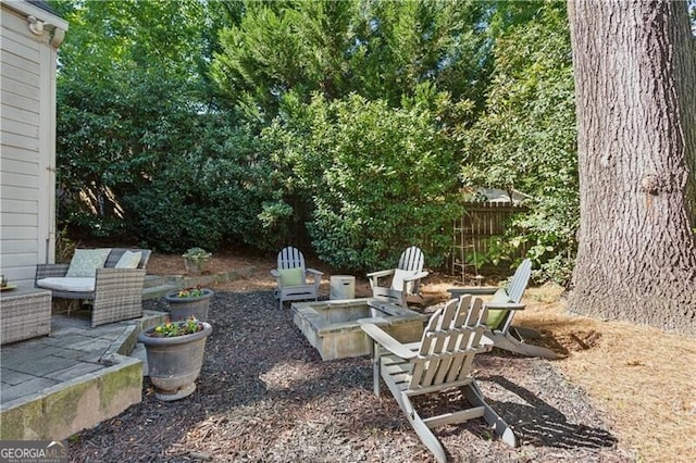 view of yard featuring a patio, an outdoor fire pit, and fence