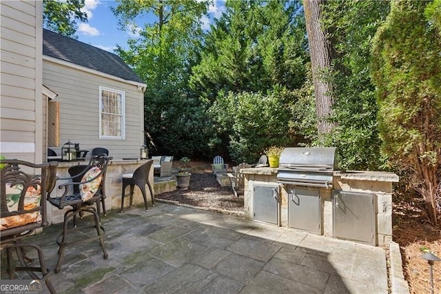 view of patio / terrace featuring exterior kitchen and a grill