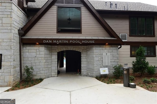 doorway to property featuring a shingled roof