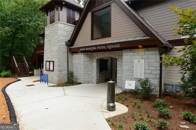 exterior space with stone siding and stairs