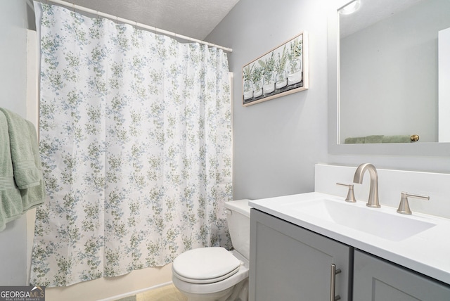 full bathroom featuring toilet, a textured ceiling, and vanity