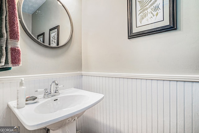 bathroom featuring a wainscoted wall and a sink