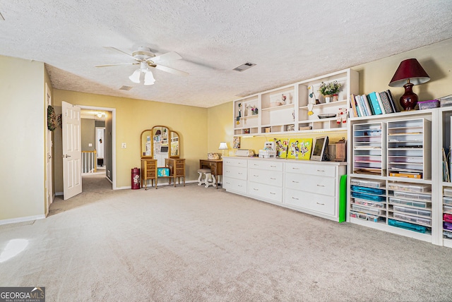 interior space with light colored carpet, visible vents, ceiling fan, a textured ceiling, and baseboards