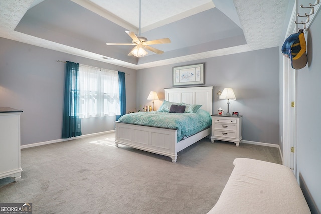 carpeted bedroom with a raised ceiling, visible vents, and baseboards