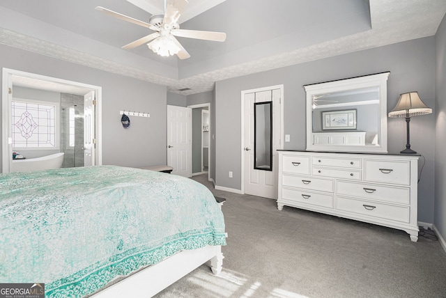 bedroom with connected bathroom, baseboards, a raised ceiling, and carpet flooring