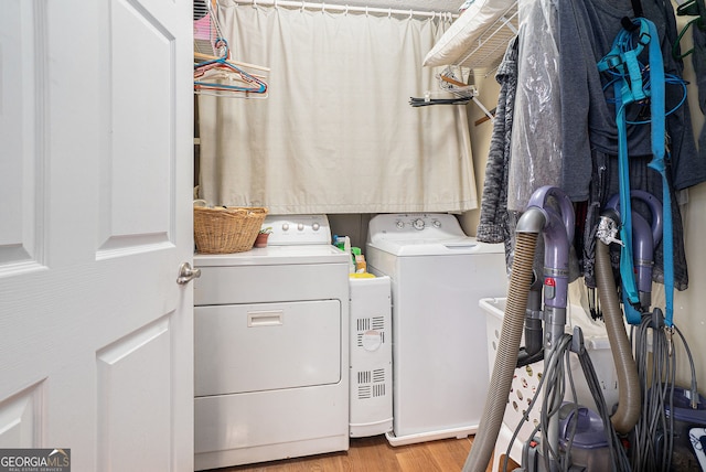 laundry area with washing machine and dryer, laundry area, and wood finished floors