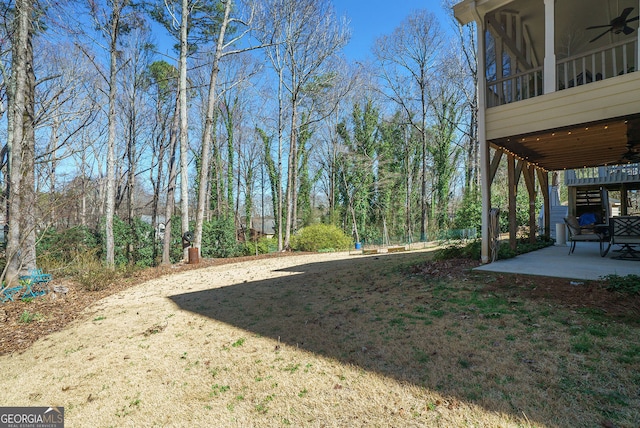 view of yard featuring a sunroom, a patio area, and ceiling fan