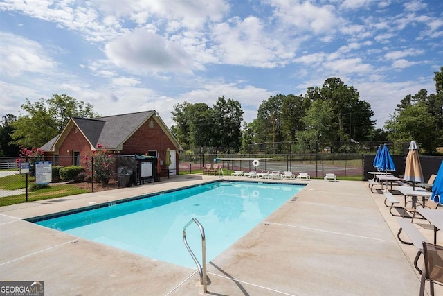 community pool featuring a patio and fence