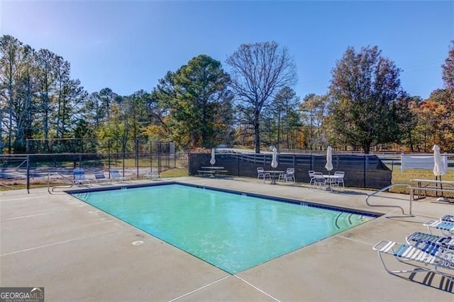 pool with fence and a patio