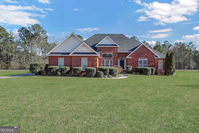 view of front of property featuring a front yard and brick siding