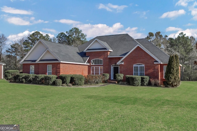 traditional-style house featuring brick siding and a front yard