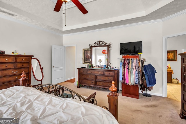 carpeted bedroom featuring a raised ceiling, ornamental molding, ceiling fan, a textured ceiling, and baseboards