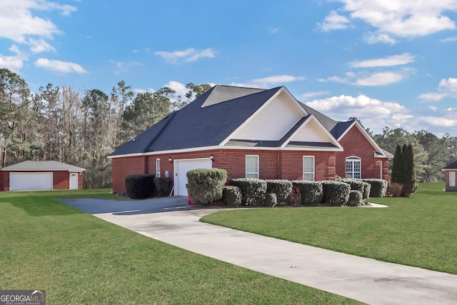 traditional home with driveway, a front yard, an outbuilding, and brick siding