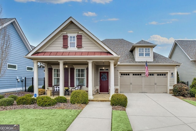 view of front facade with covered porch, a garage, a shingled roof, driveway, and a standing seam roof