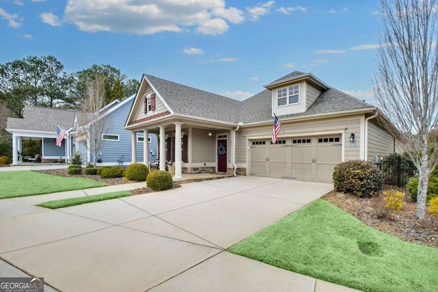 view of front of property featuring covered porch, concrete driveway, a shingled roof, and an attached garage