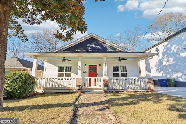 bungalow with covered porch, ceiling fan, and a front yard