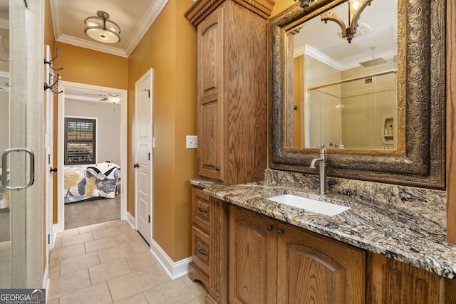 bathroom featuring baseboards, ornamental molding, tile patterned flooring, vanity, and a shower stall