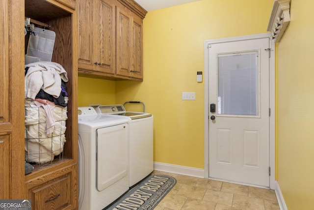 clothes washing area with cabinet space, washer and clothes dryer, and baseboards