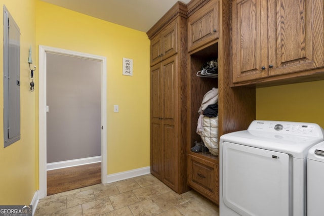 washroom featuring washing machine and dryer, cabinet space, and baseboards