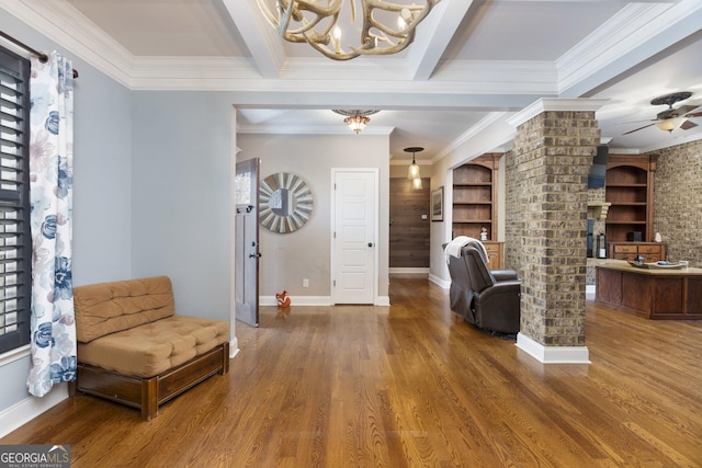 sitting room featuring crown molding, decorative columns, beamed ceiling, and wood finished floors